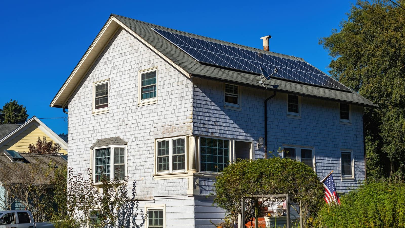 A home with a rooftop solar array under a clear blue sky