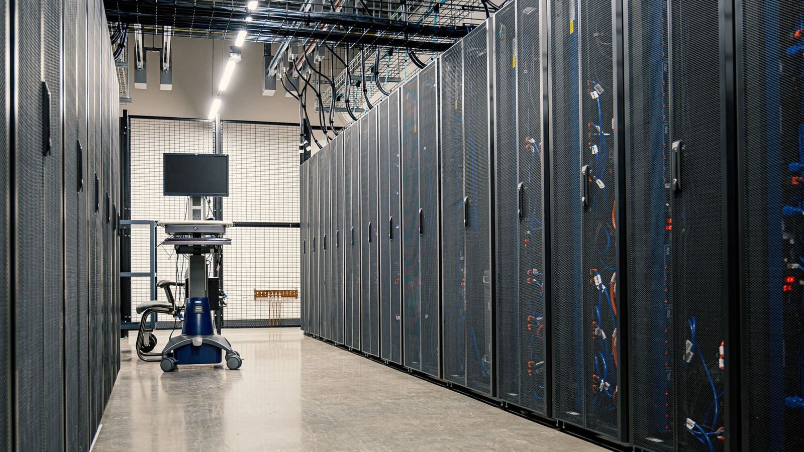 An aisle of server racks inside a data center
