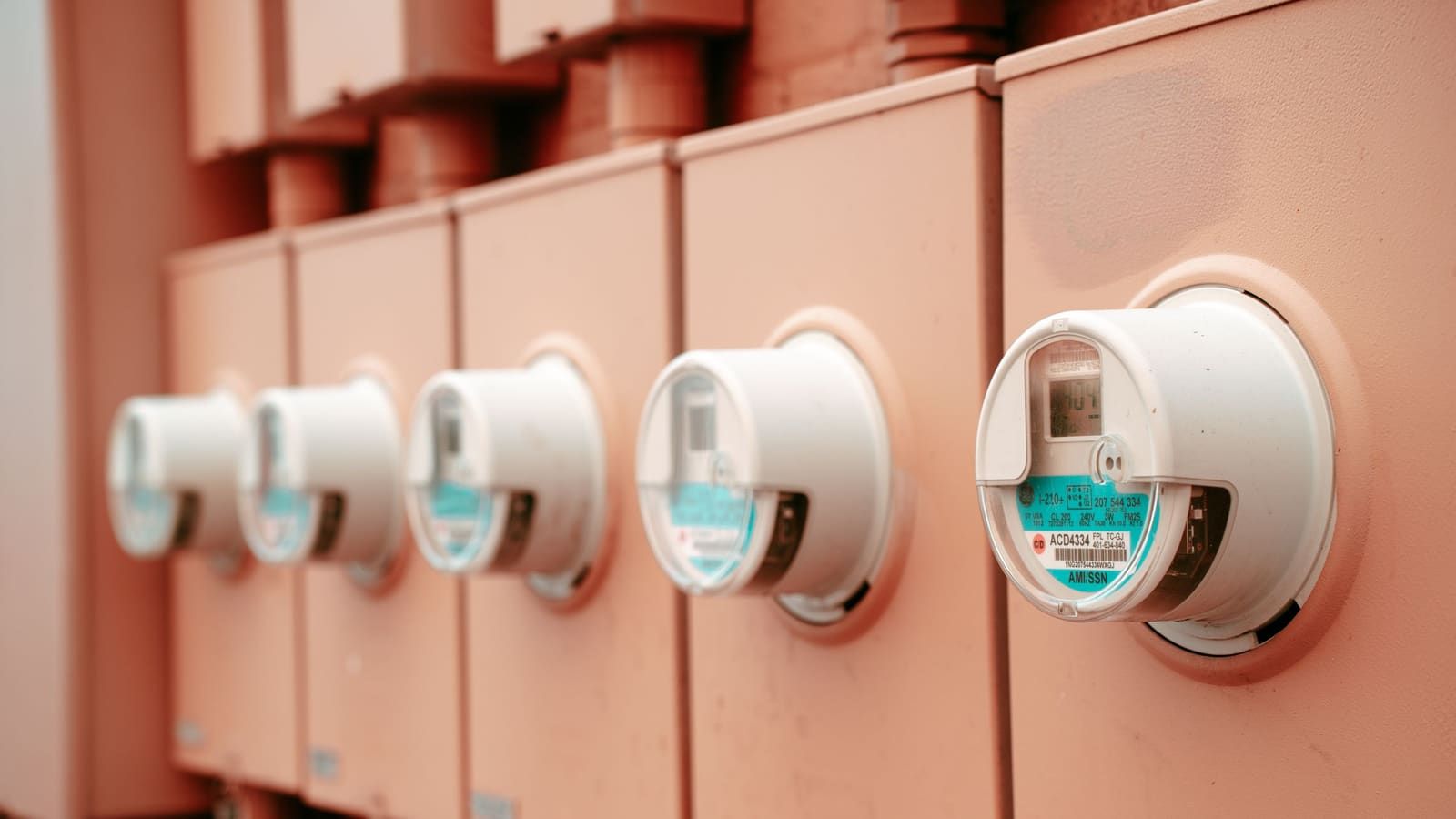 A row of residential electric meters on an exterior wall